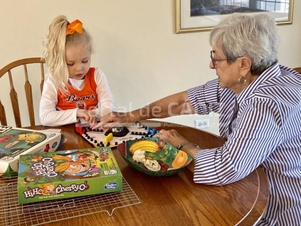 little girl playing board games with her great grandma at home generations t20 ozr4kg