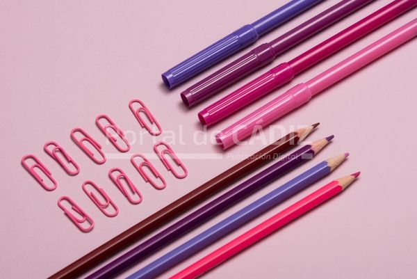 colourful pencils thumbtacks and clips over a pink p26wf9k