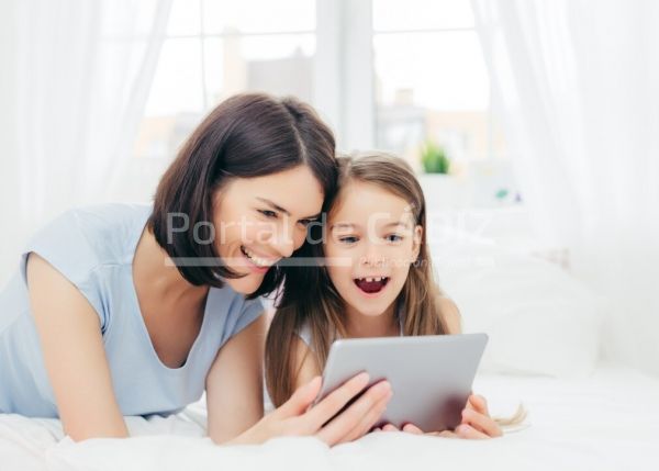 positive cheerful small female kid and her young mother watch interesting cartoon on tablet connected t20 g0y9eo