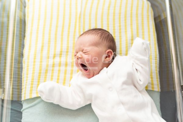 newborn baby yawning lying in a hospital crib fi 2022 11 15 14 01 15 utc