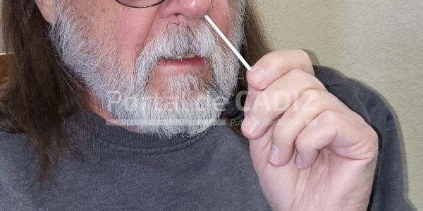 male baby boomer with a beard performing at home rapid covid 19 nasal swab test insert the collection t20 gzpwlz