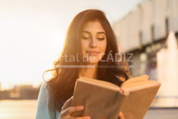 young woman reading book outdoors walking on city 2022 12 16 09 04 47 utc