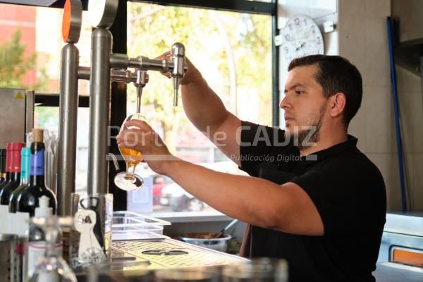 latin bartender pouring beer from beer tap in a ba 2022 09 09 19 16 02 utc